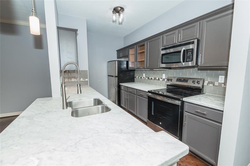 a kitchen with stainless steel appliances granite countertop a sink and a stove top oven