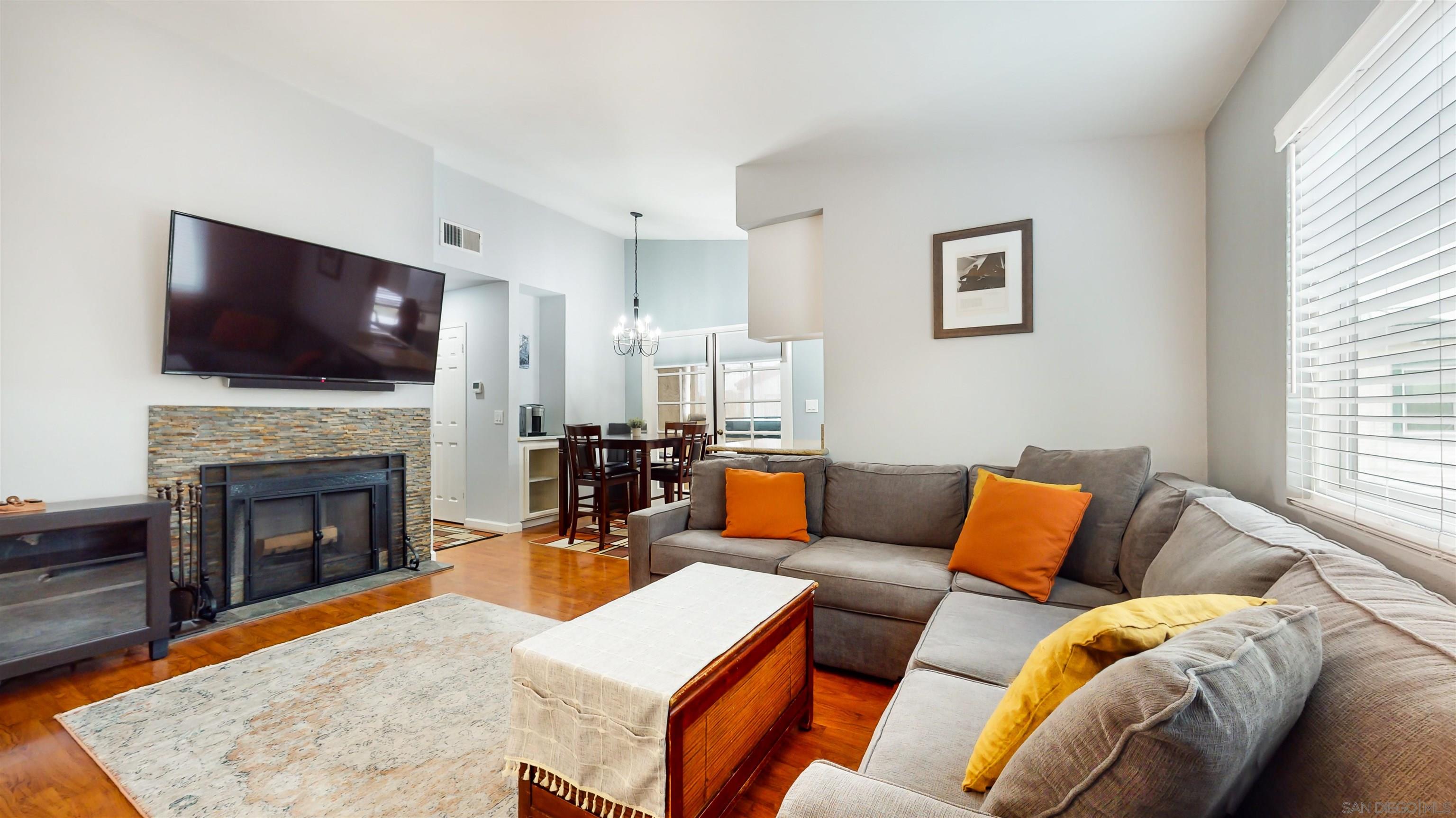 a living room with furniture a flat screen tv and a fireplace