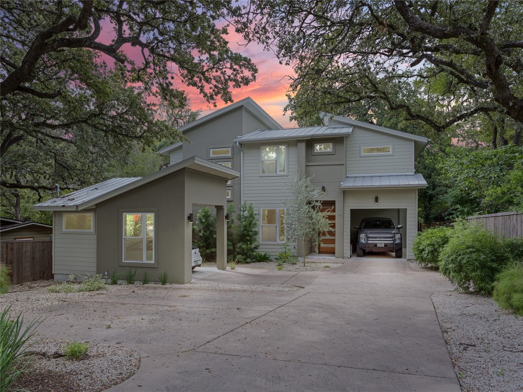 a front view of a house with yard and trees