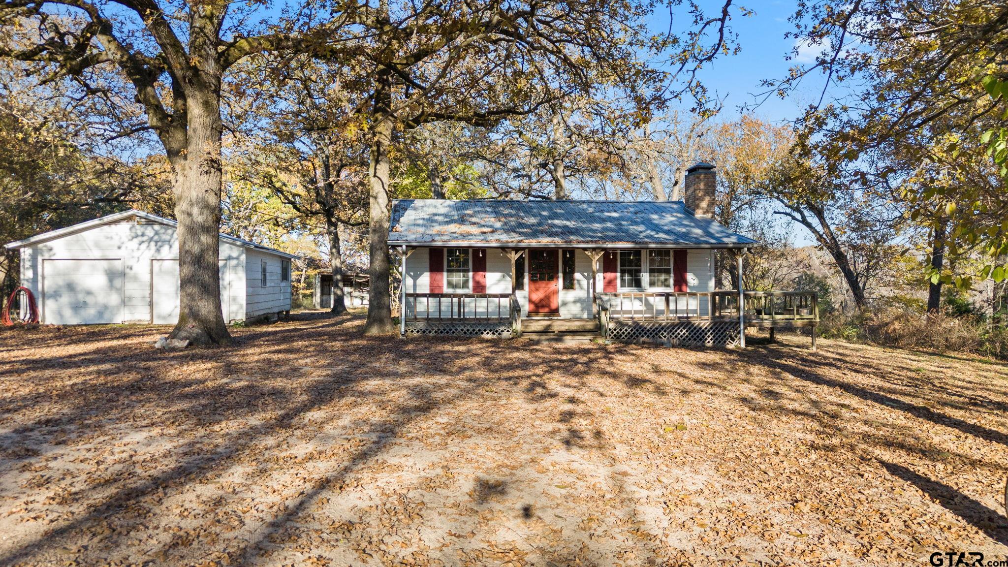 a view of a house with a yard tree and wooden fence