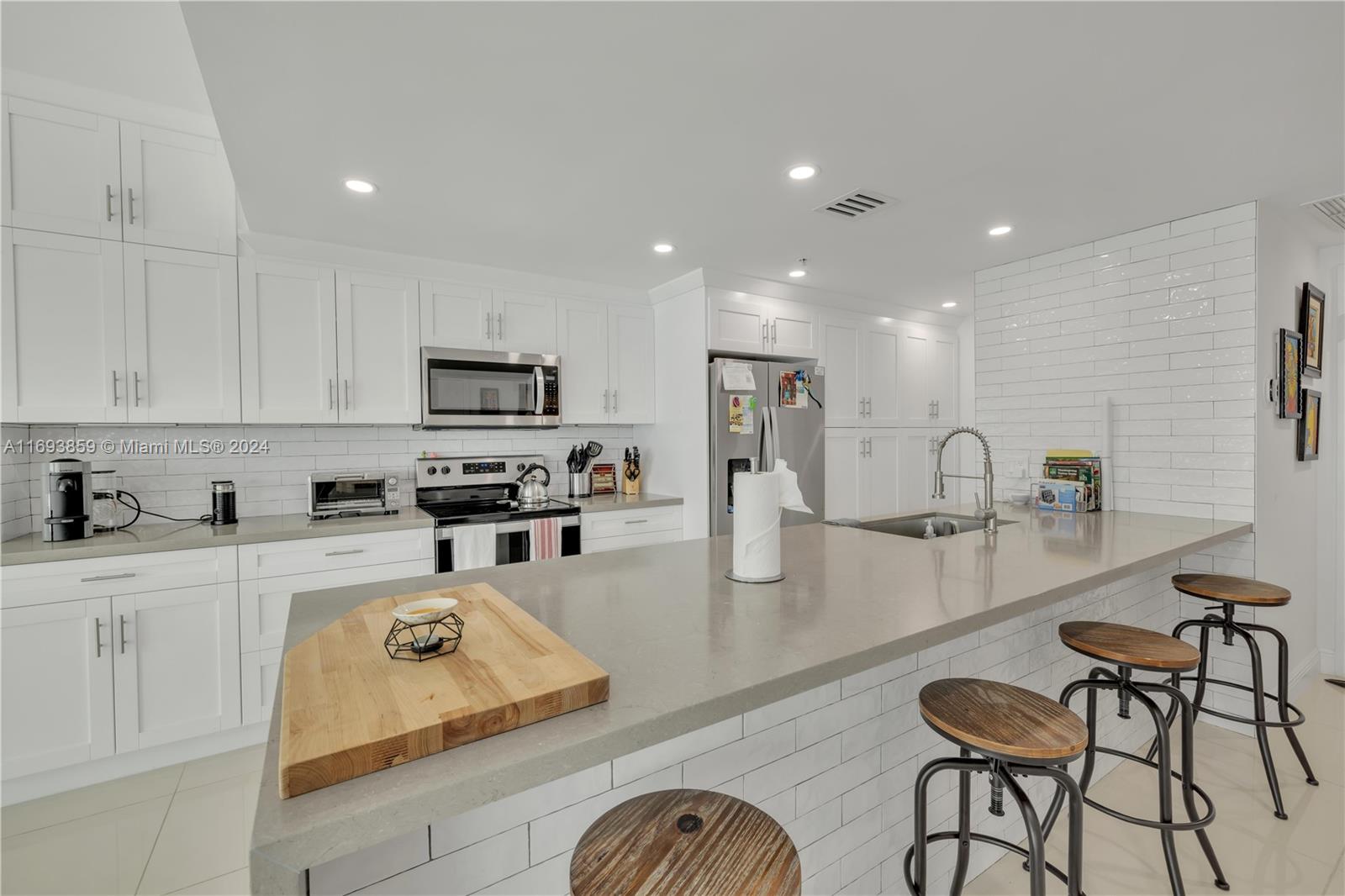 a kitchen with stainless steel appliances granite countertop a refrigerator and a stove top oven