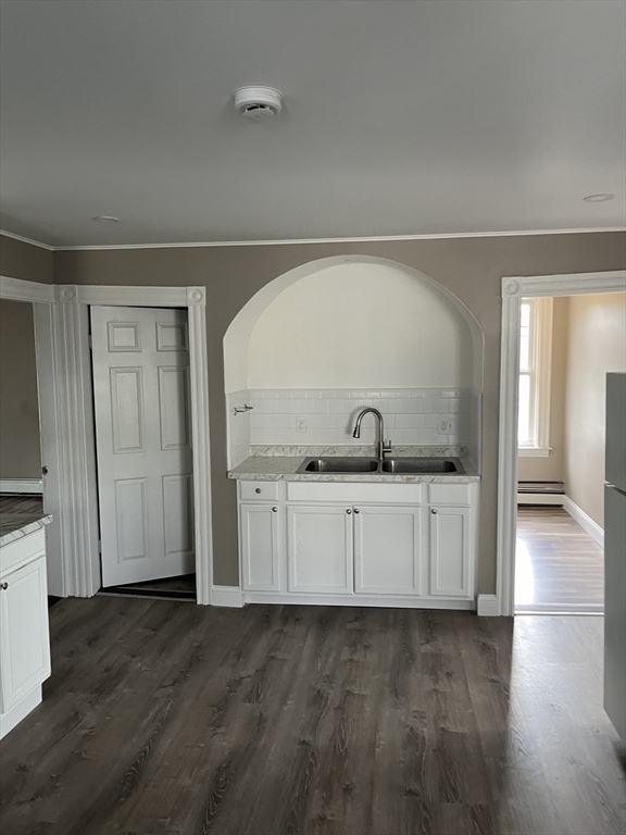 a living room with a sink and a wooden floor