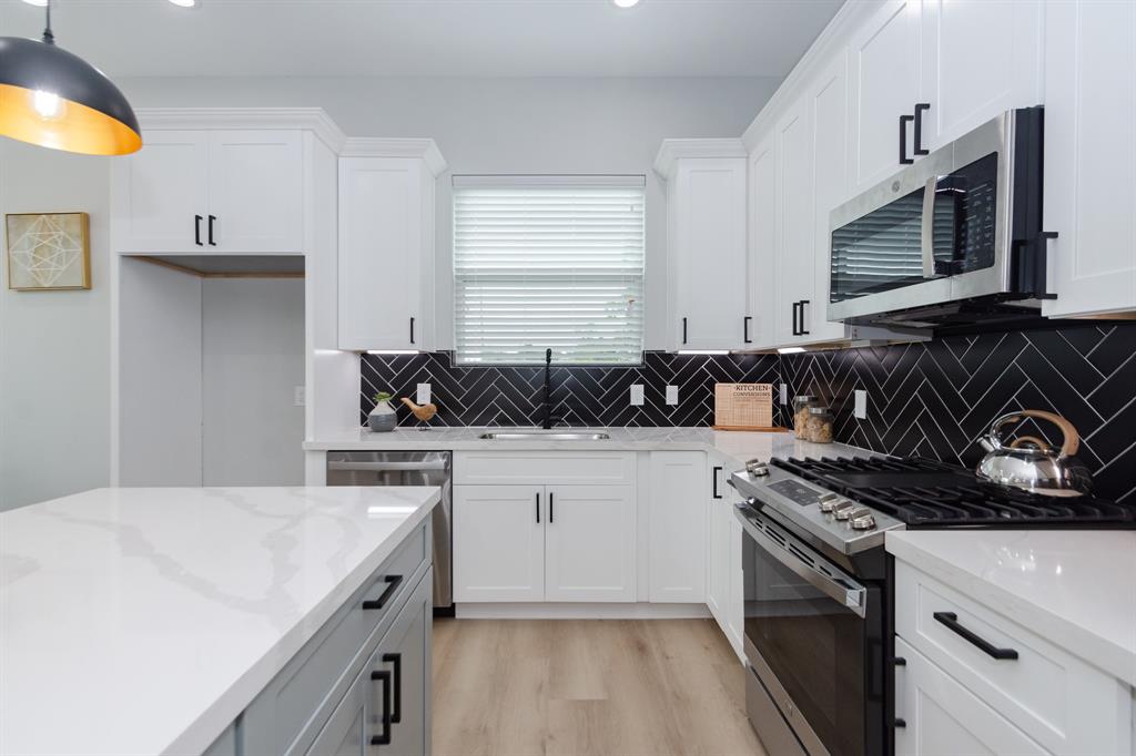 a kitchen with a sink a stove and cabinets