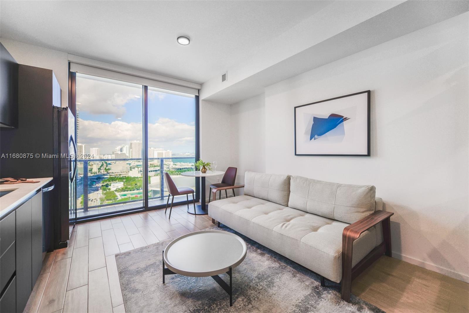 a living room with furniture and a floor to ceiling window