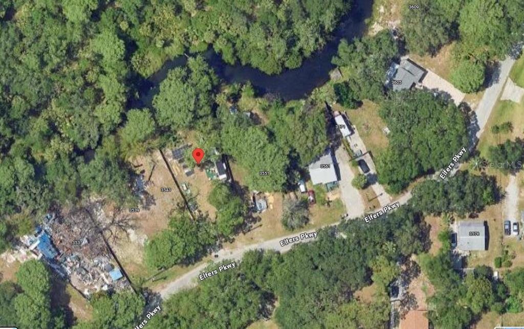 an aerial view of residential house with outdoor space and trees all around