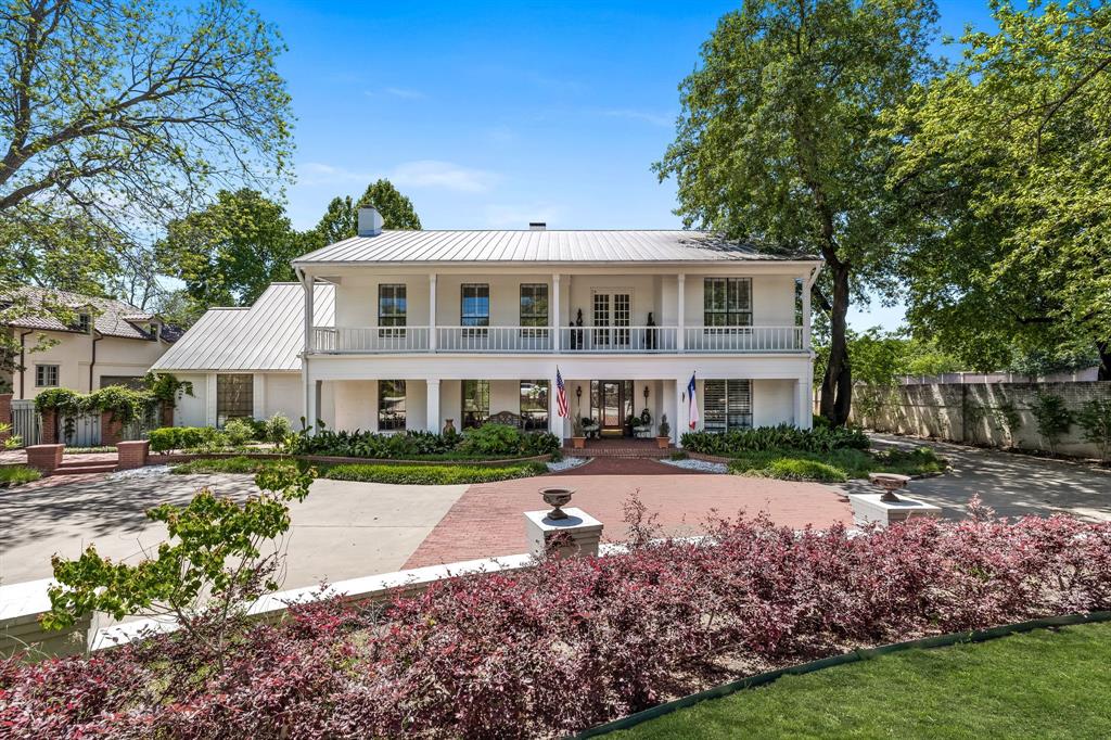 a view of a big house with a big yard and large trees