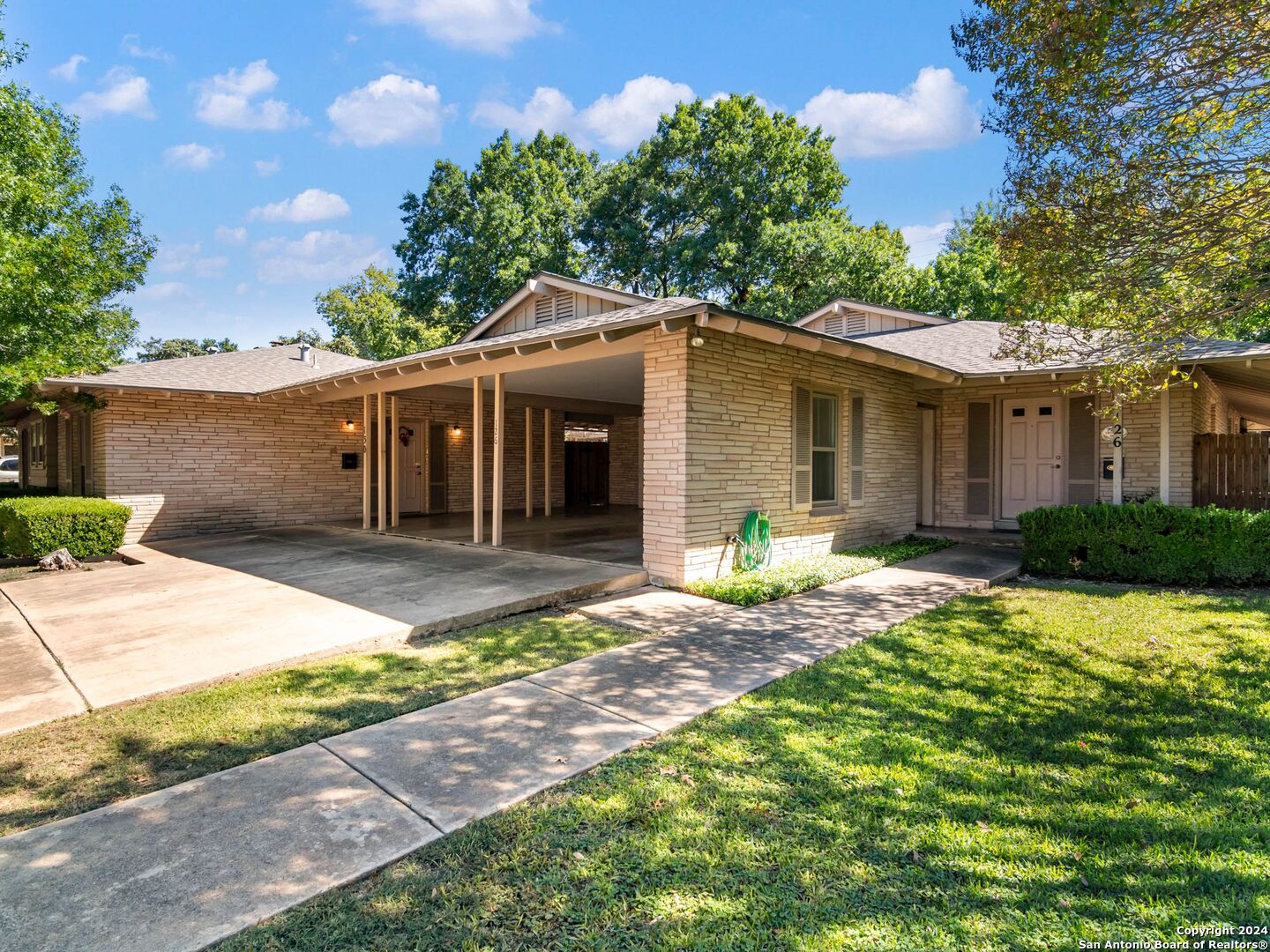 a front view of a house with yard patio and green space