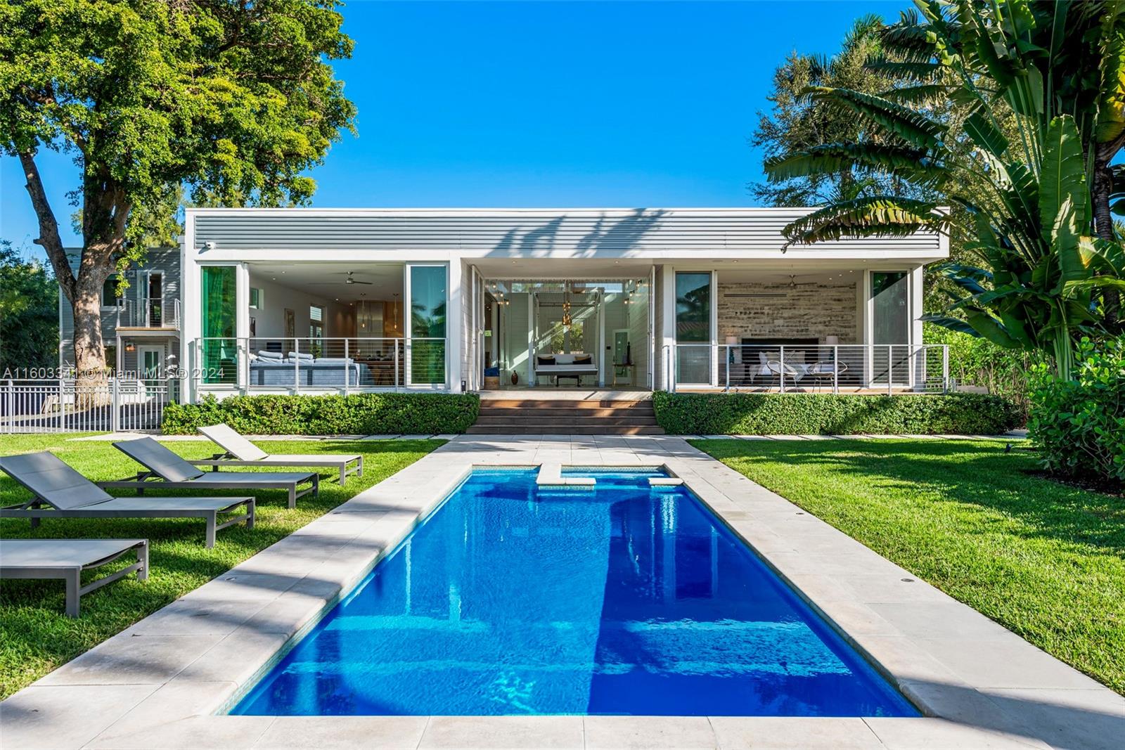 a view of an house with swimming pool and chairs