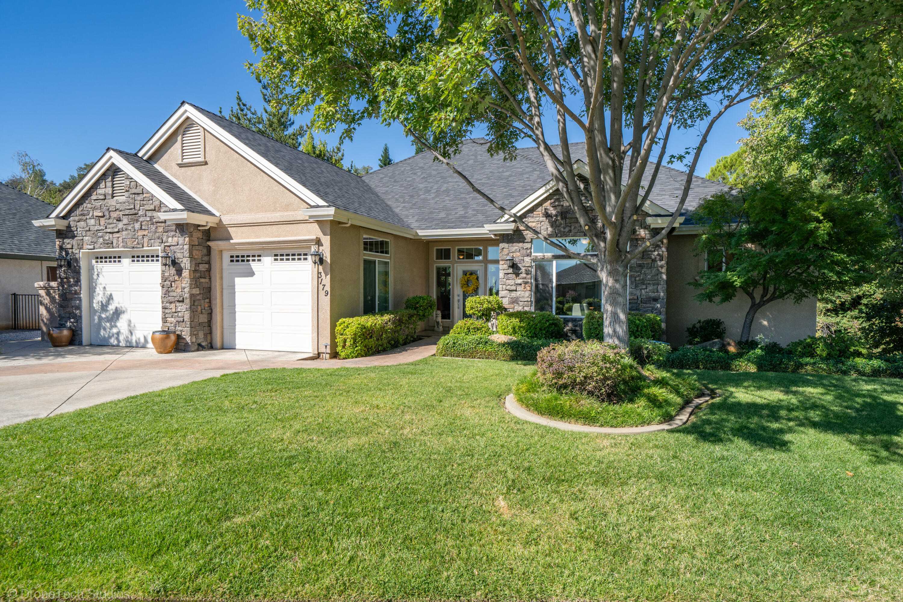 a front view of a house with a yard and green space