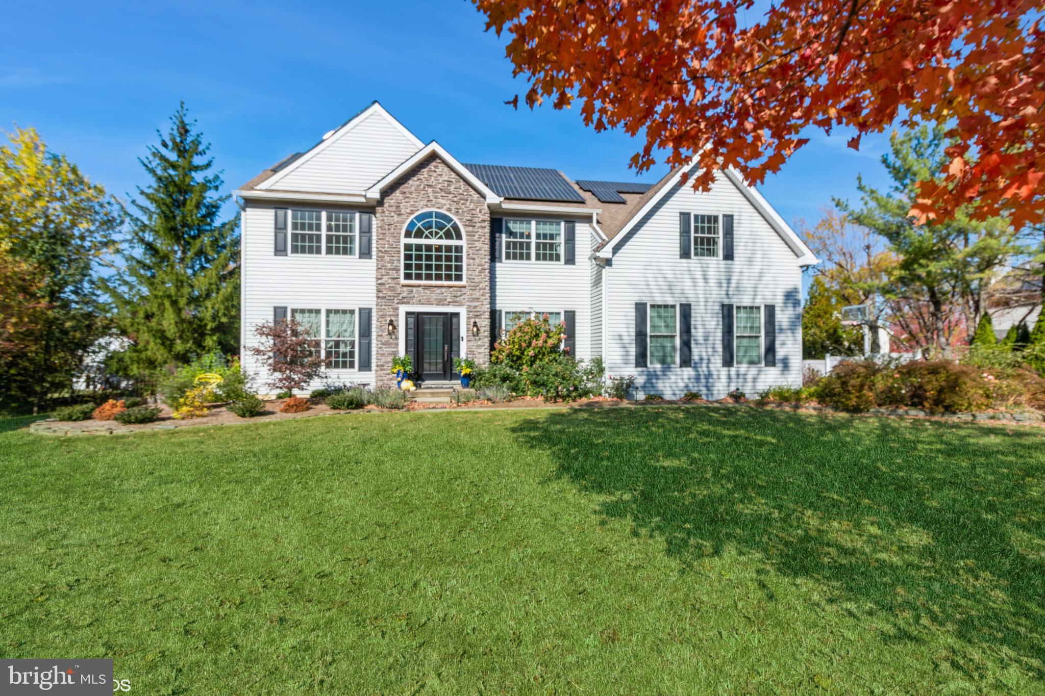 a front view of a house with a yard and trees