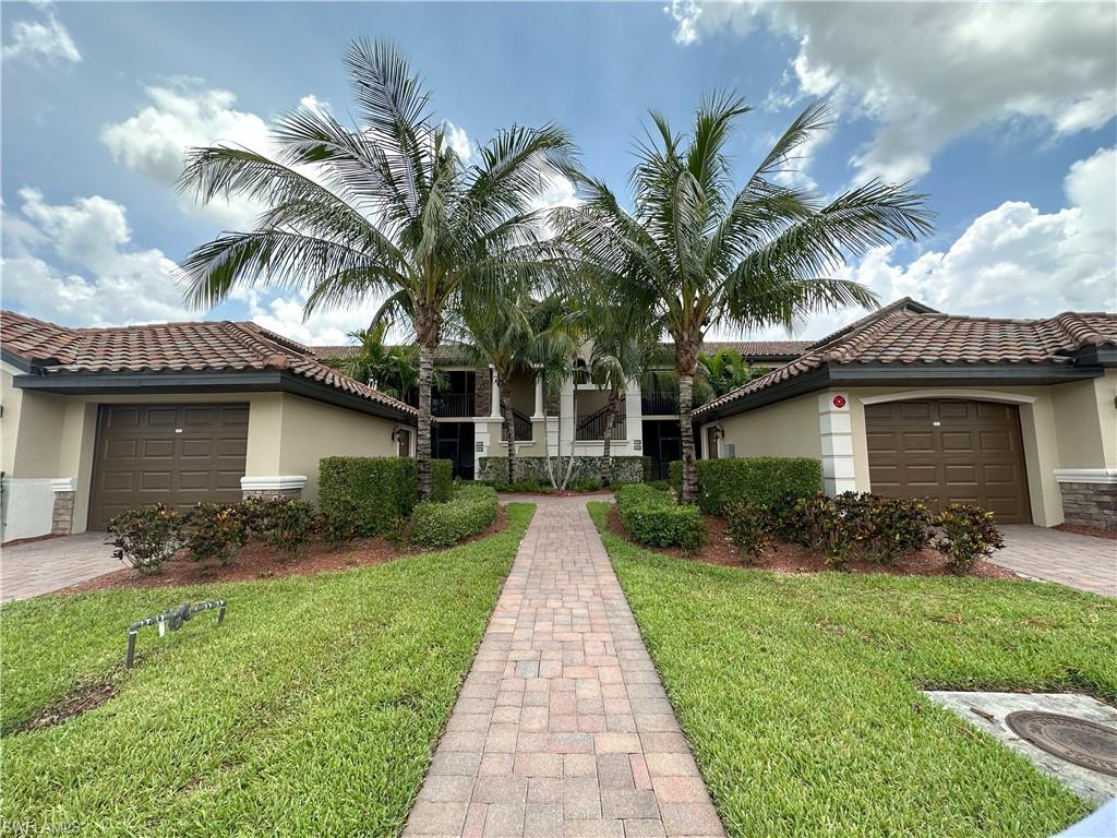 a front view of a house with a garden and palm trees