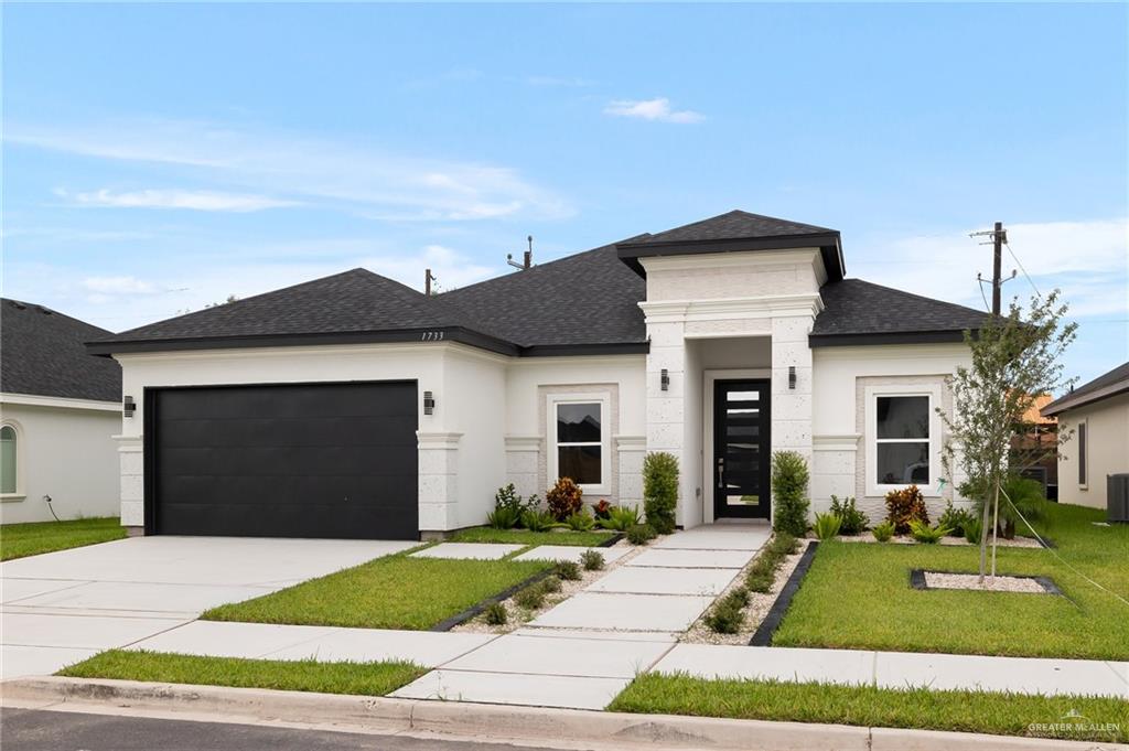 a front view of a house with a yard and garage