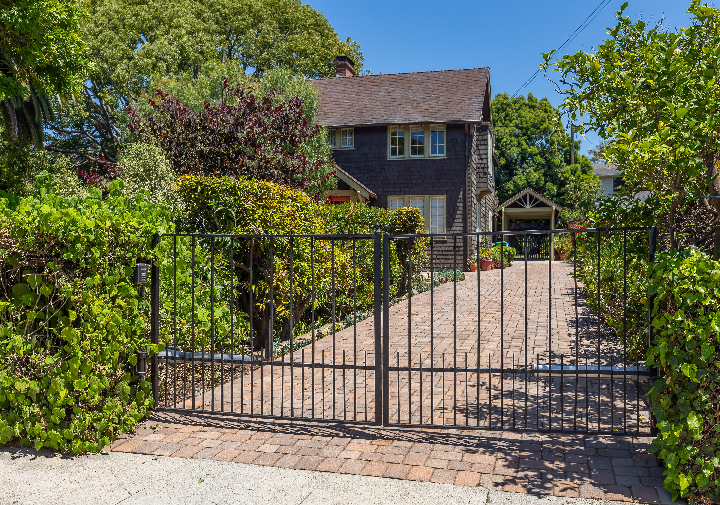 a view of a brick house with large trees