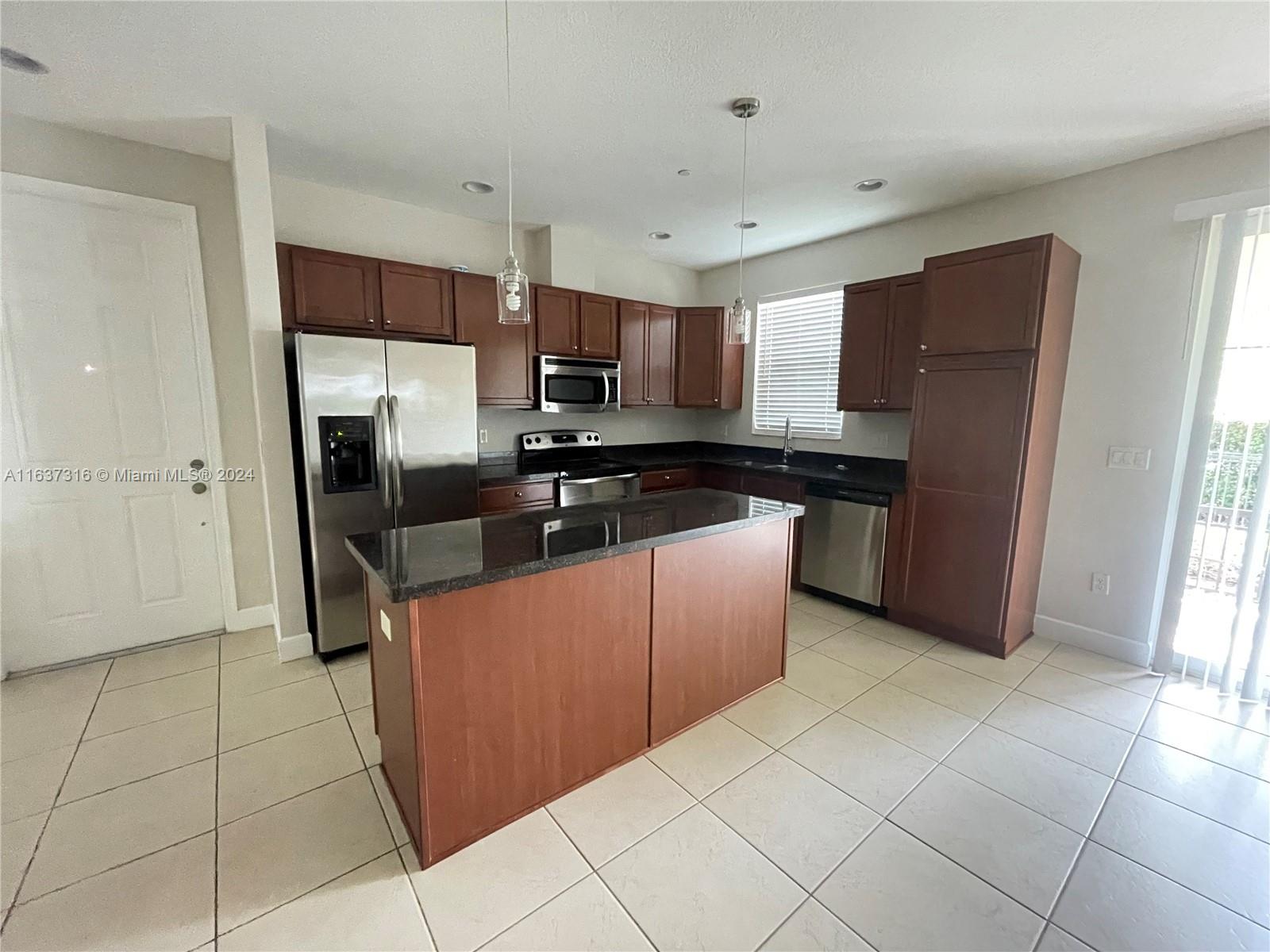 a kitchen with stainless steel appliances granite countertop a refrigerator and a sink