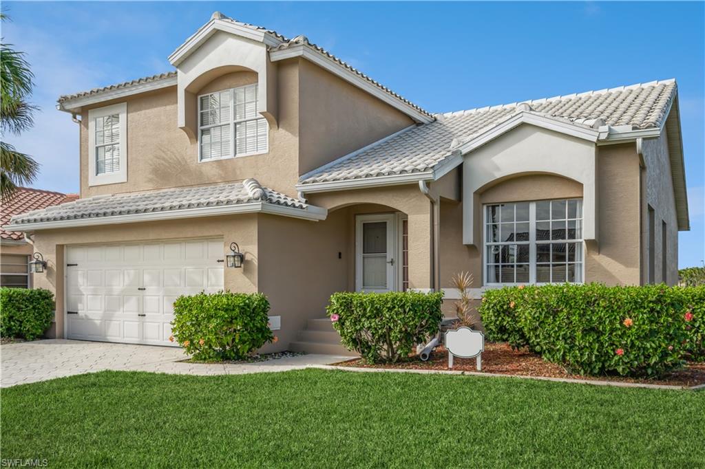 a front view of a house with a yard and garage