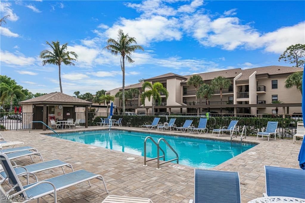 a view of a swimming pool with a table and chairs under an umbrella