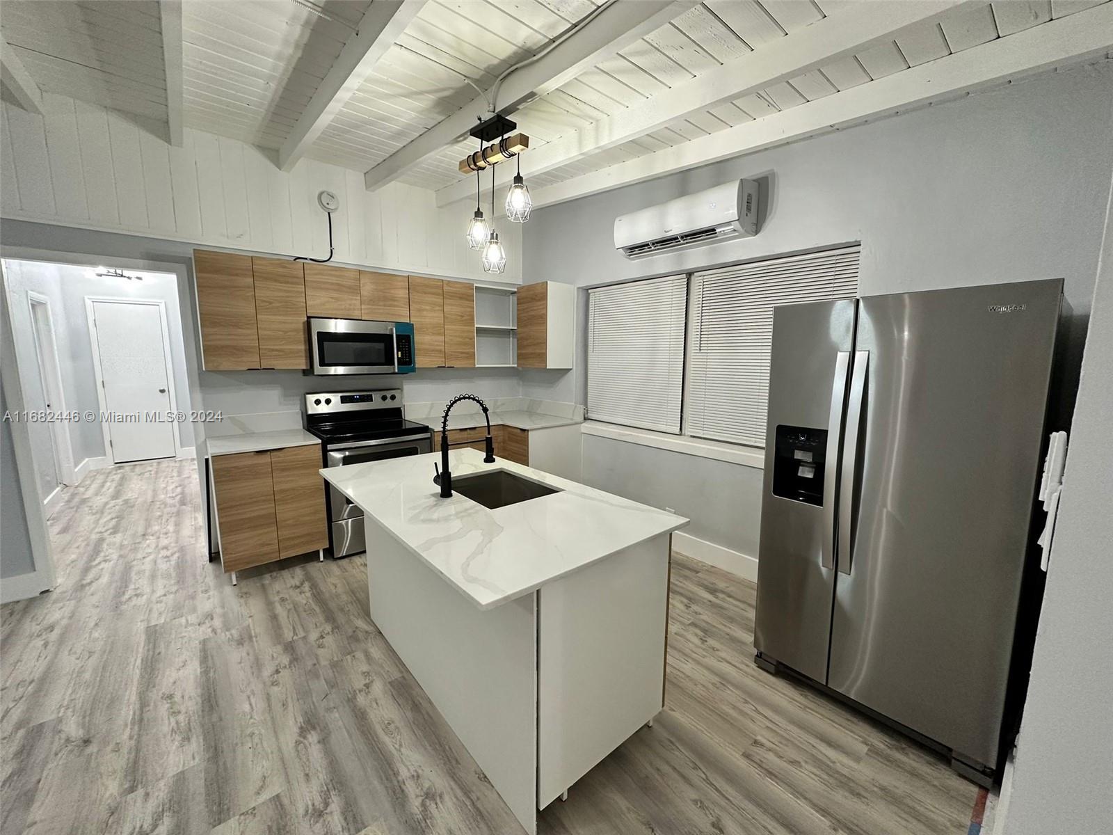 a kitchen with kitchen island white cabinets and stainless steel appliances