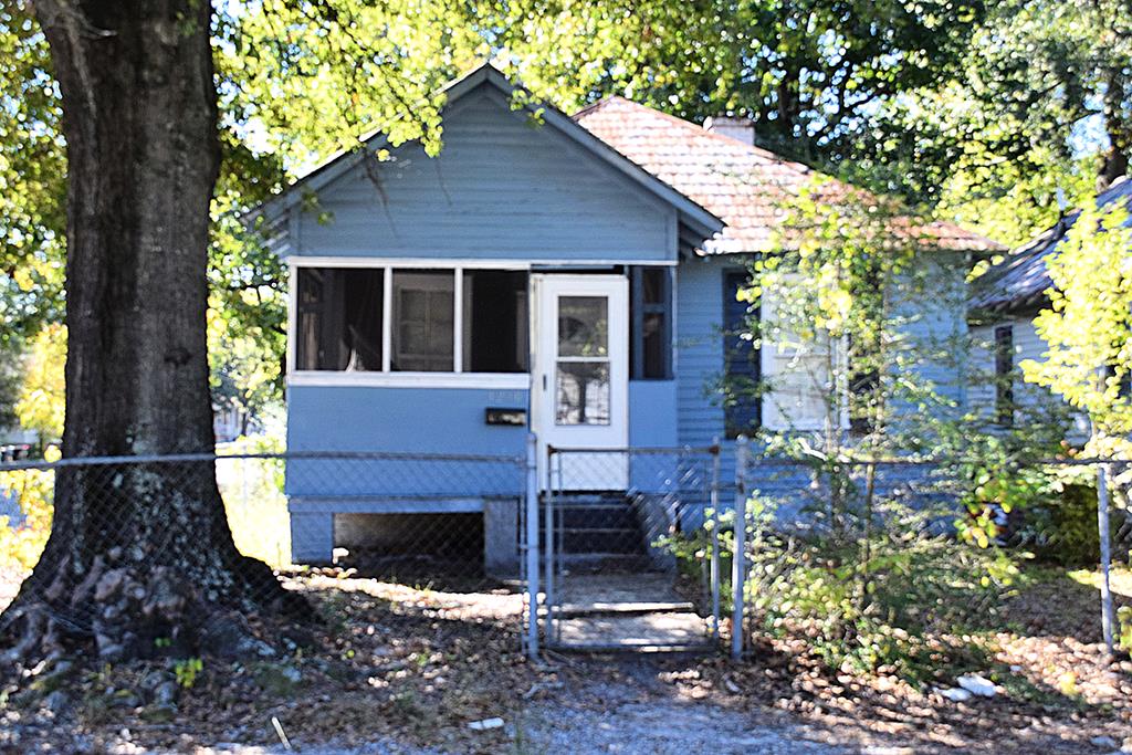 a view of house with yard and outdoor seating