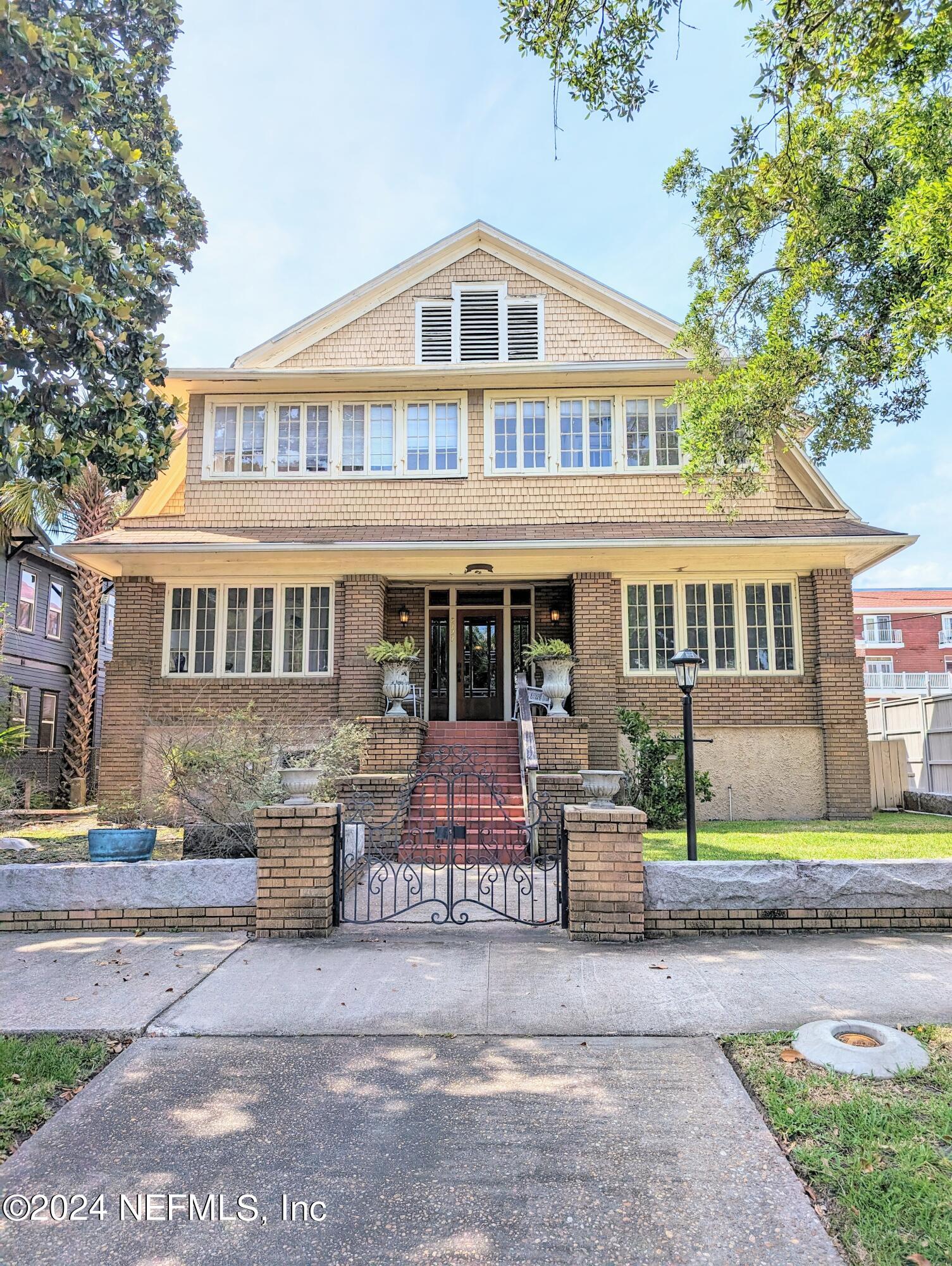 a front view of a house with a garden and plants