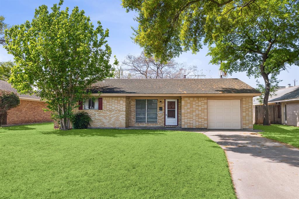 a view of a house with a yard and large tree