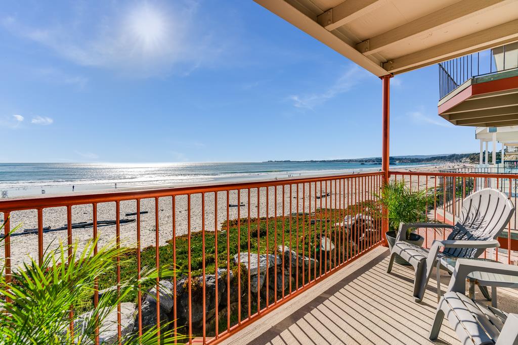 a balcony with wooden floor and outdoor seating