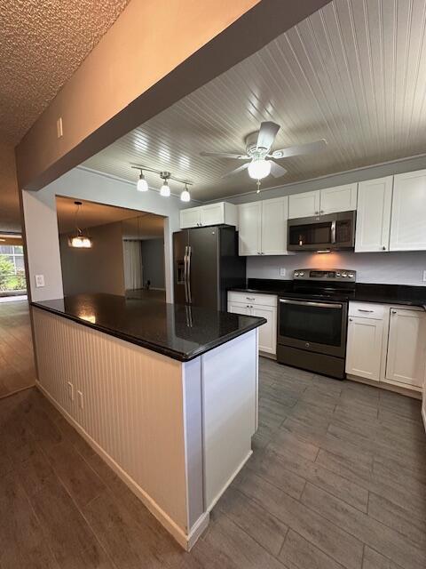 a kitchen with stainless steel appliances kitchen island granite countertop a stove a sink and a microwave