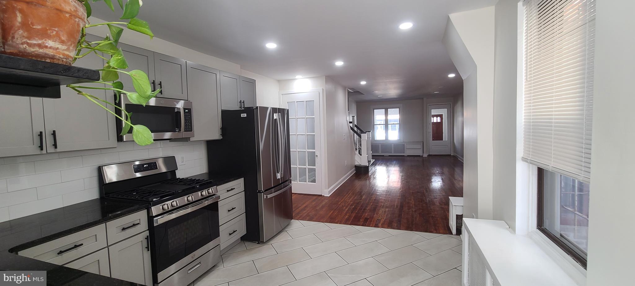 a kitchen with stainless steel appliances granite countertop a refrigerator and a stove