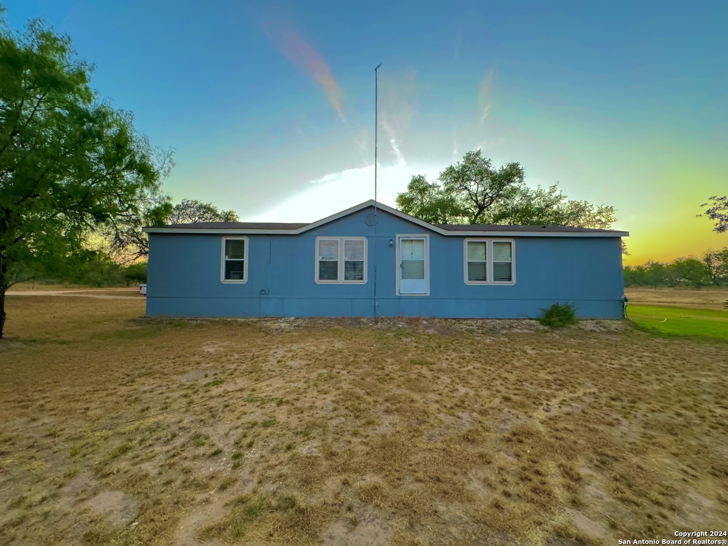 a house is sitting in middle of a yard