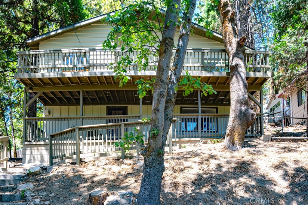 a front view of a house with a tree in it