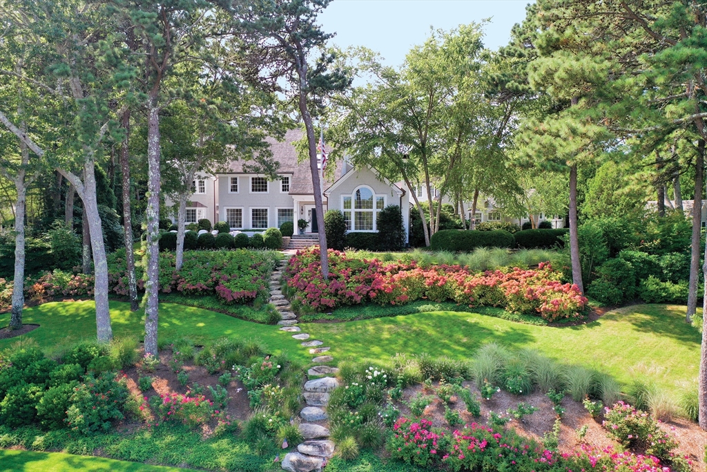 a front view of a house with a big yard and potted plants