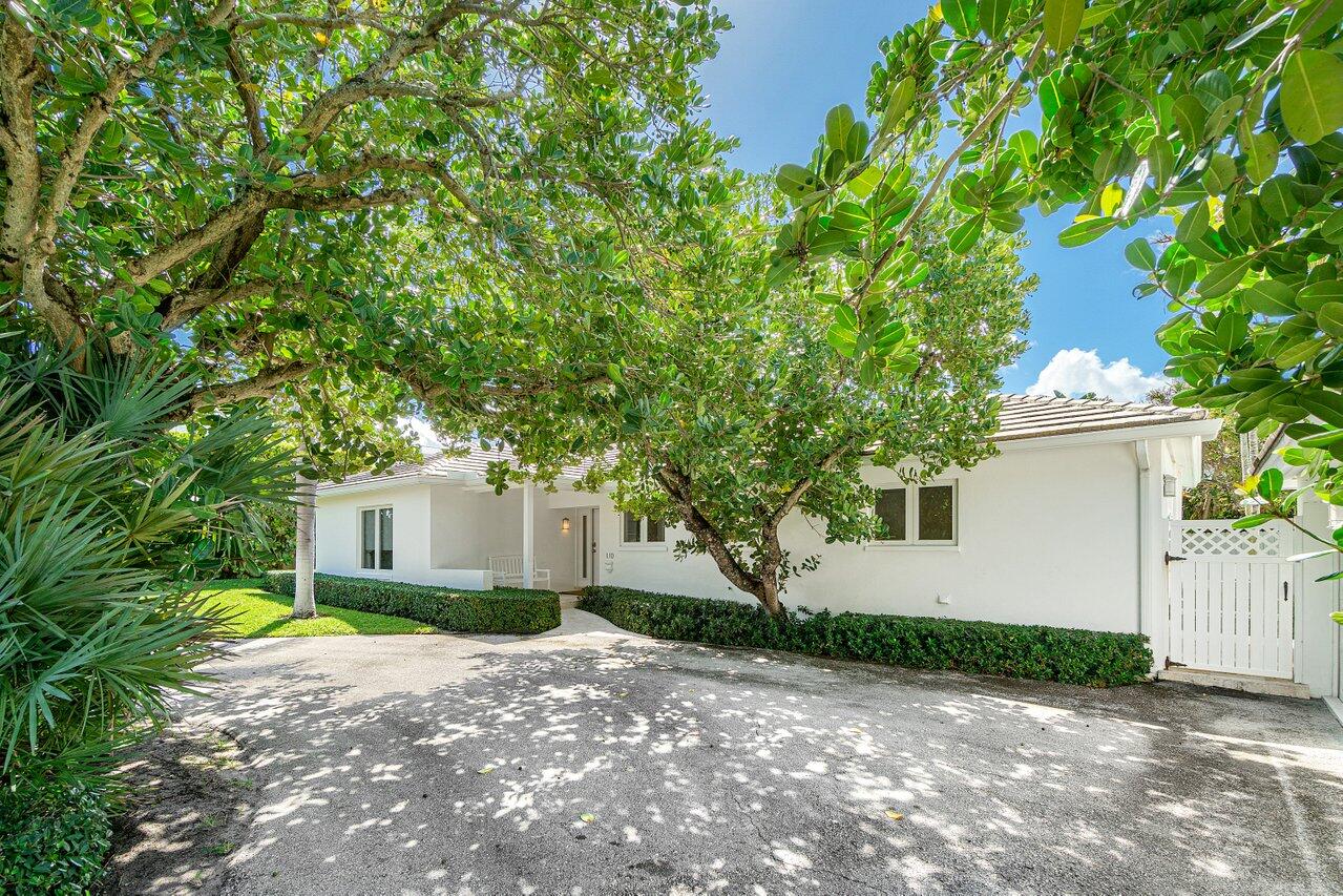 a view of a house with a small yard and tree s