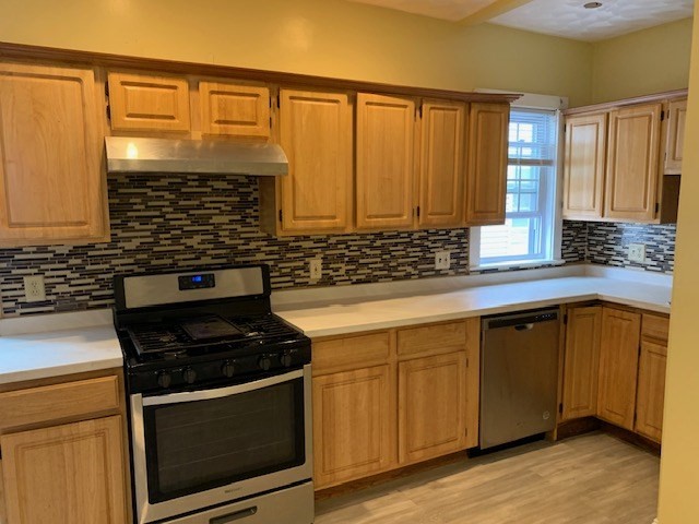 a kitchen with stainless steel appliances a stove sink and cabinets