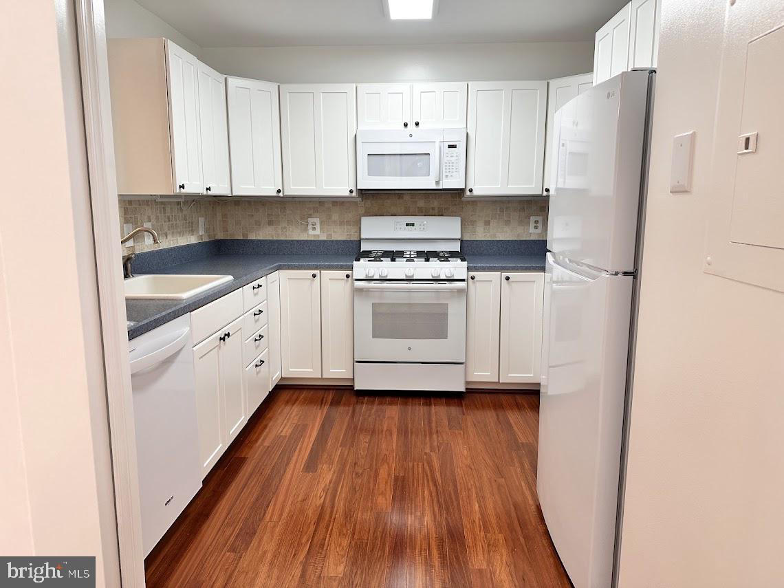 a kitchen with white cabinets and white appliances