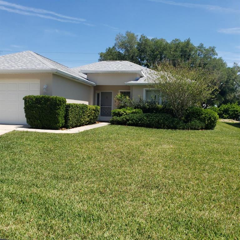 a front view of a house with yard and green space