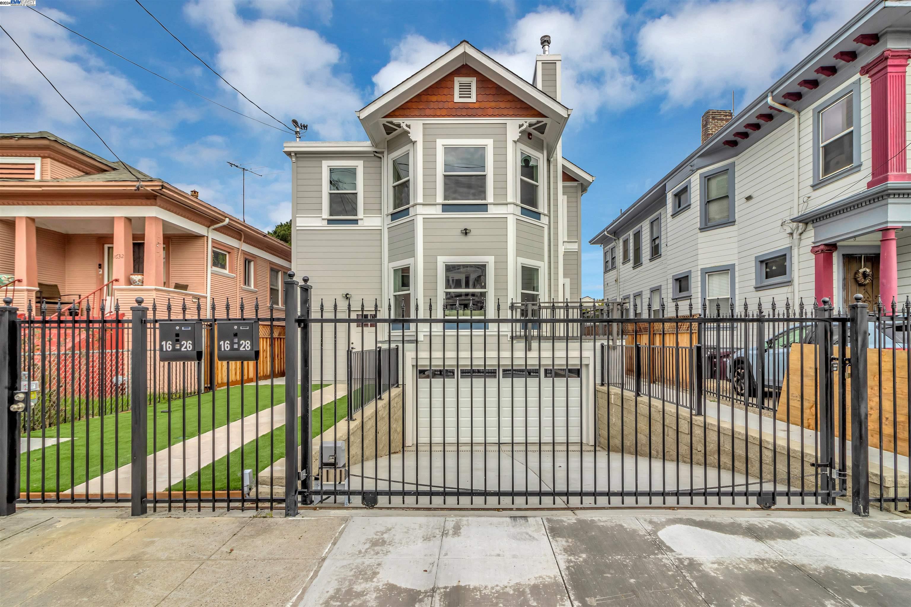 a front view of a house with a iron gate