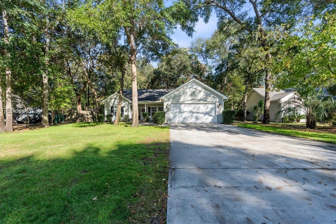 Single story home with a garage and a front lawn