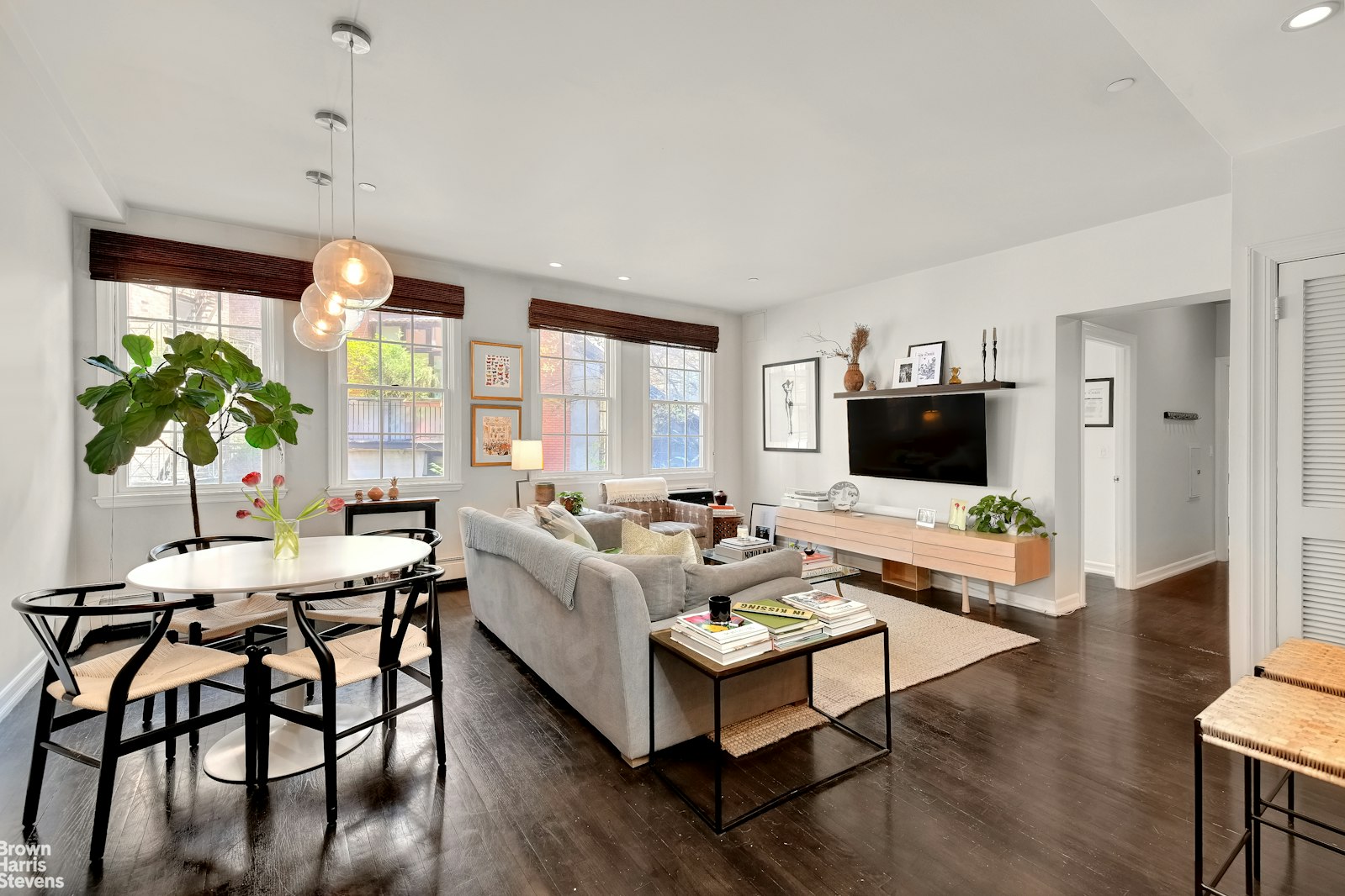 a living room with furniture a flat screen tv and a large window