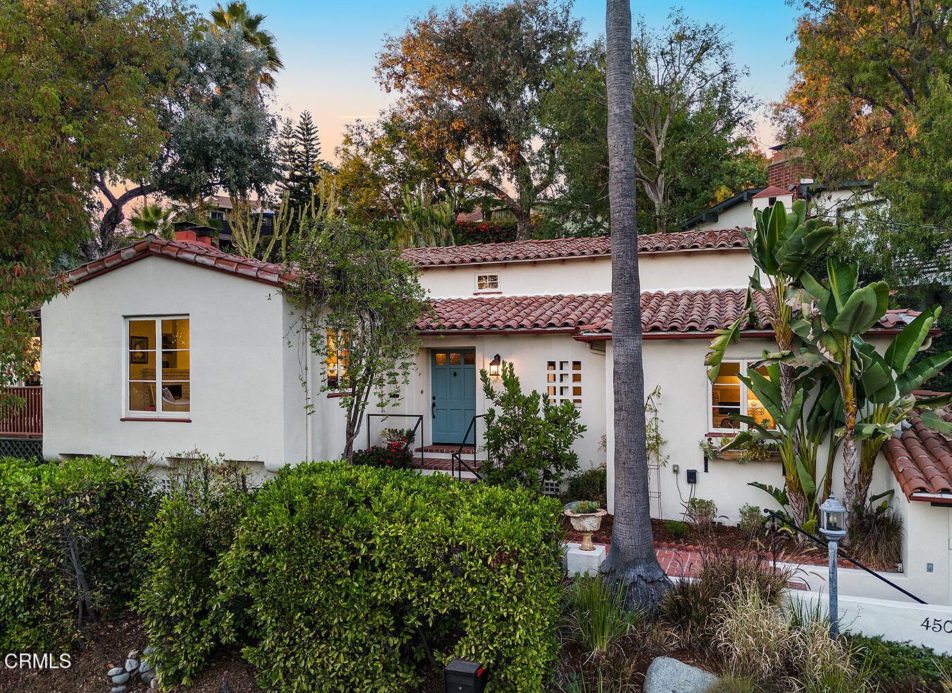 a front view of house with yard and trees in the background