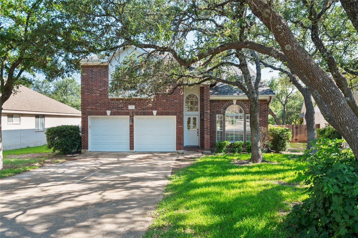 a front view of a house with yard and green space