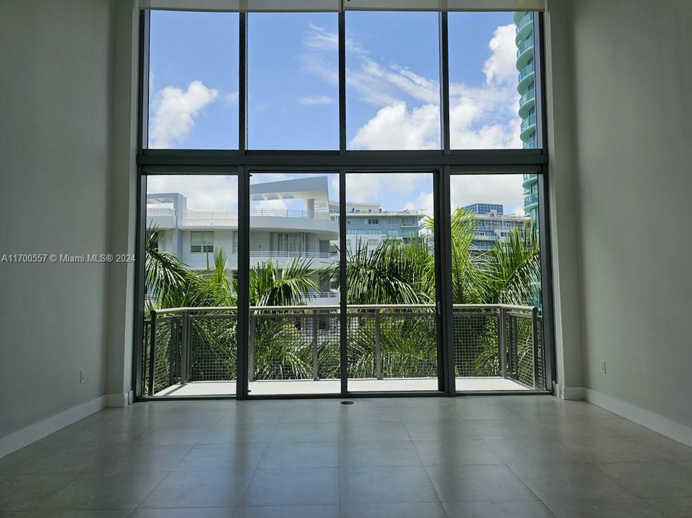 a view of an empty room with wooden floor and windows