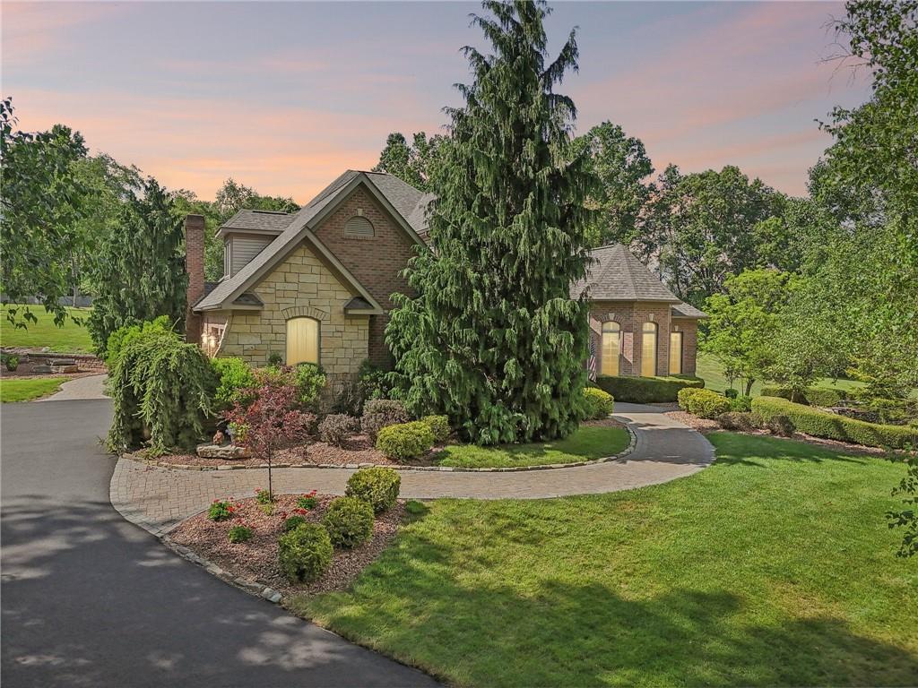 a front view of a house with a yard and trees