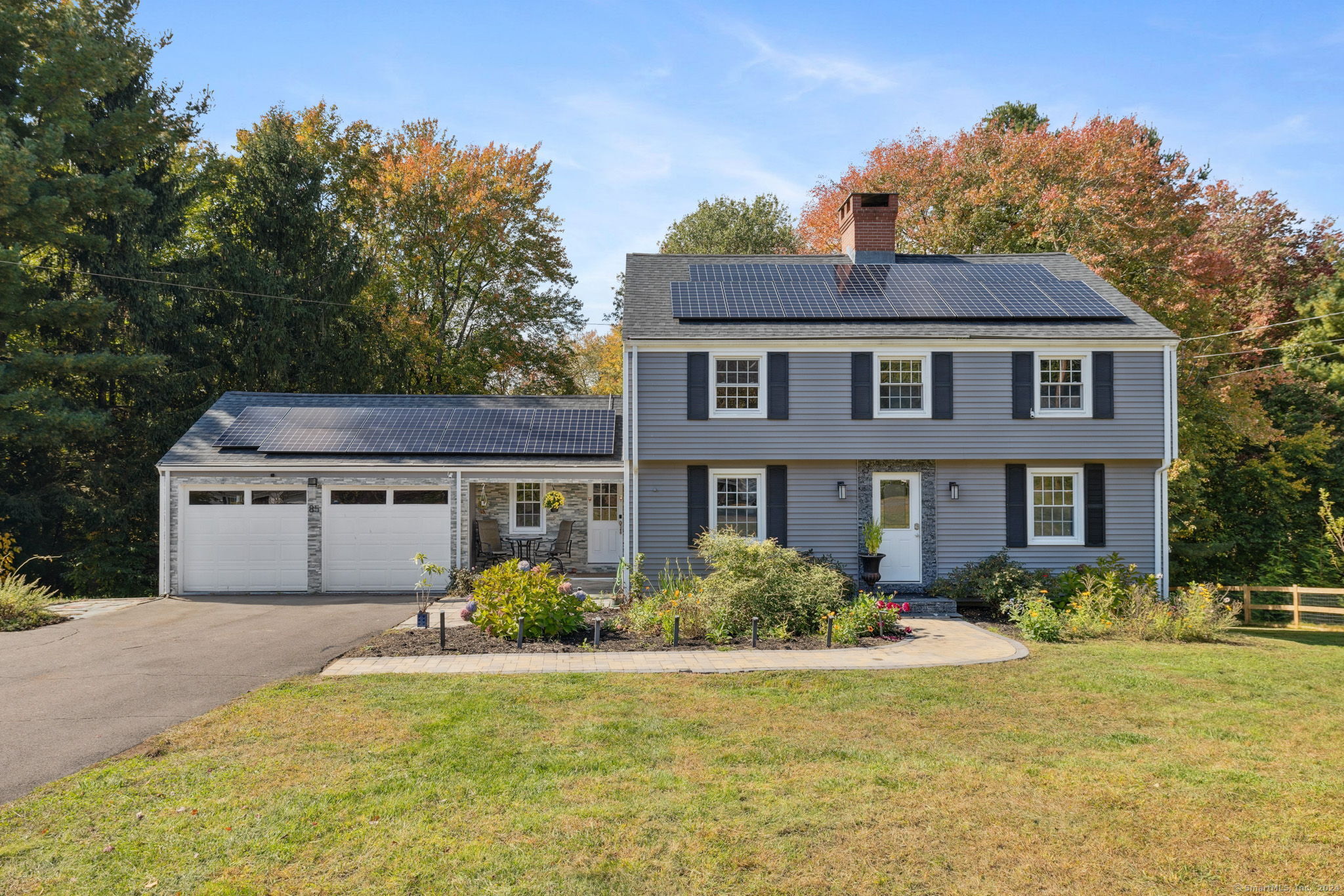 a front view of house with yard and trees around