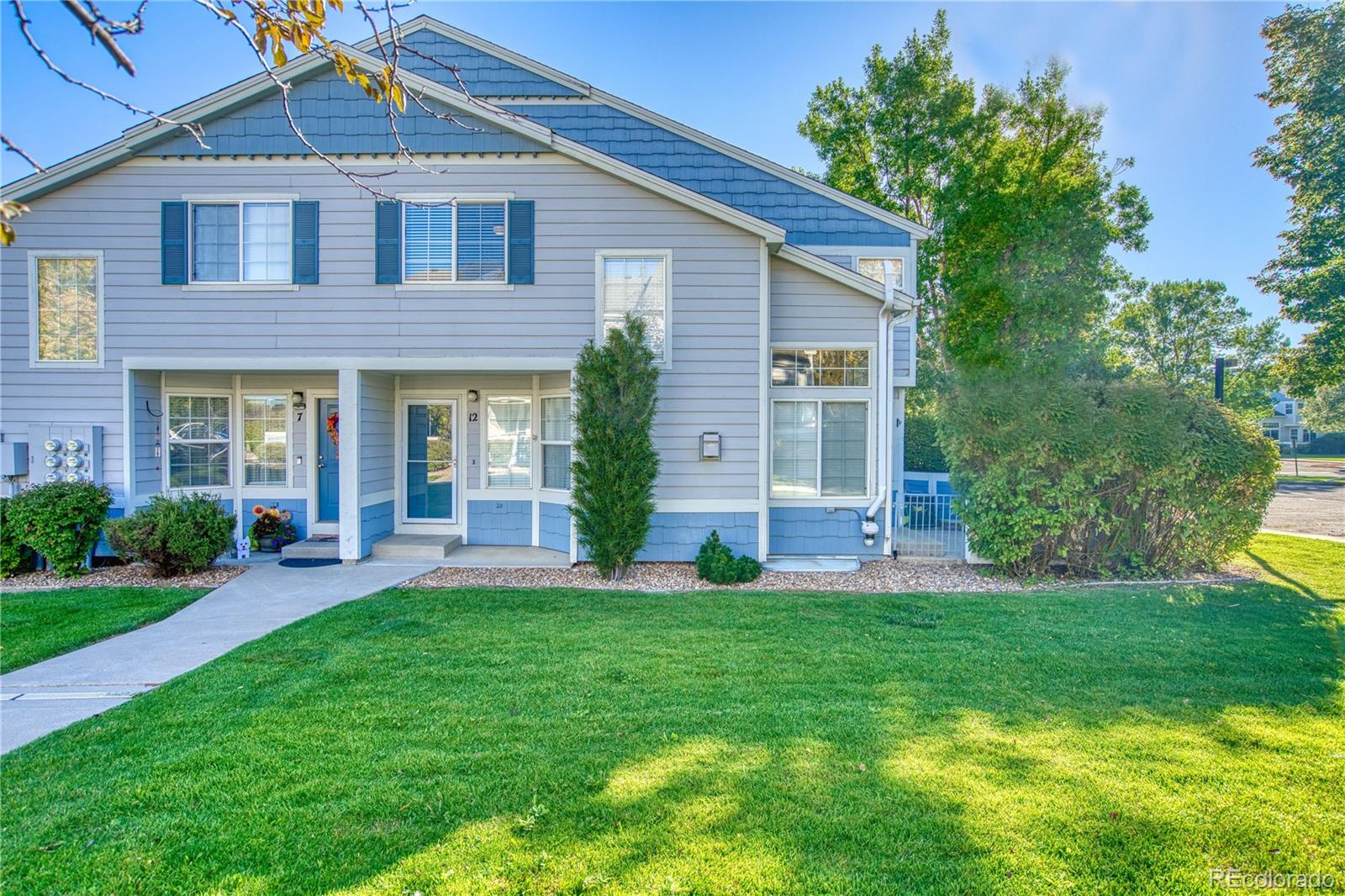 a front view of a house with a yard and trees