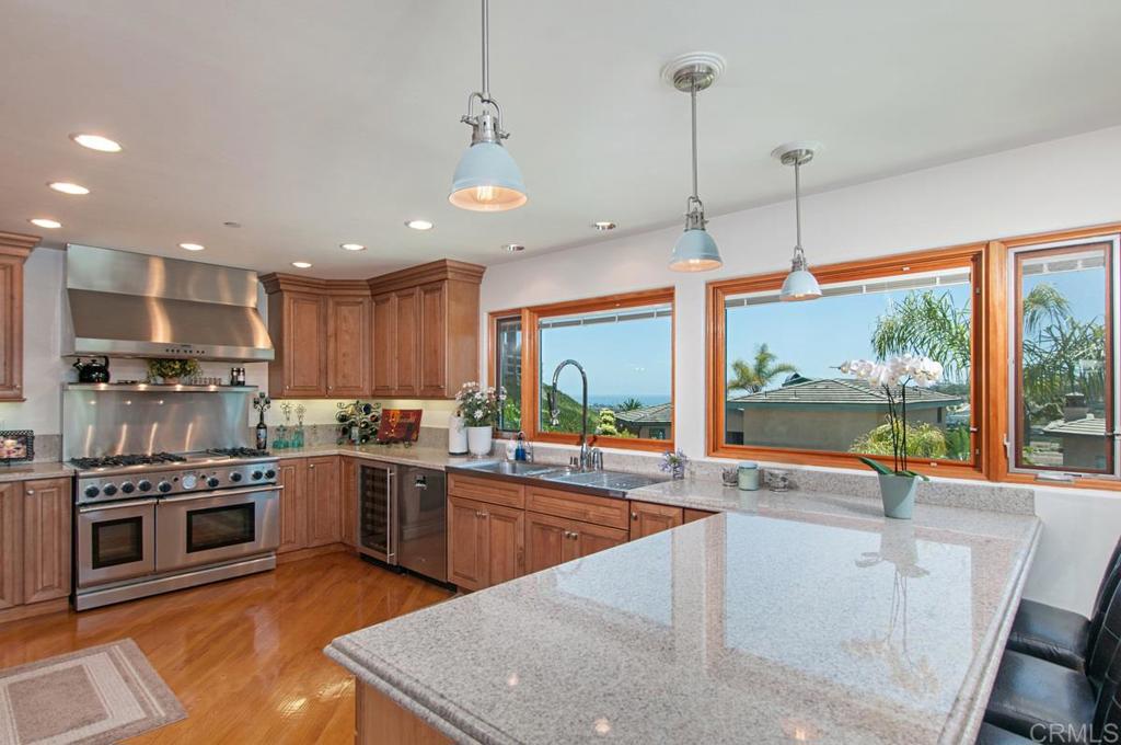 a kitchen with stainless steel appliances granite countertop a stove a sink and a refrigerator