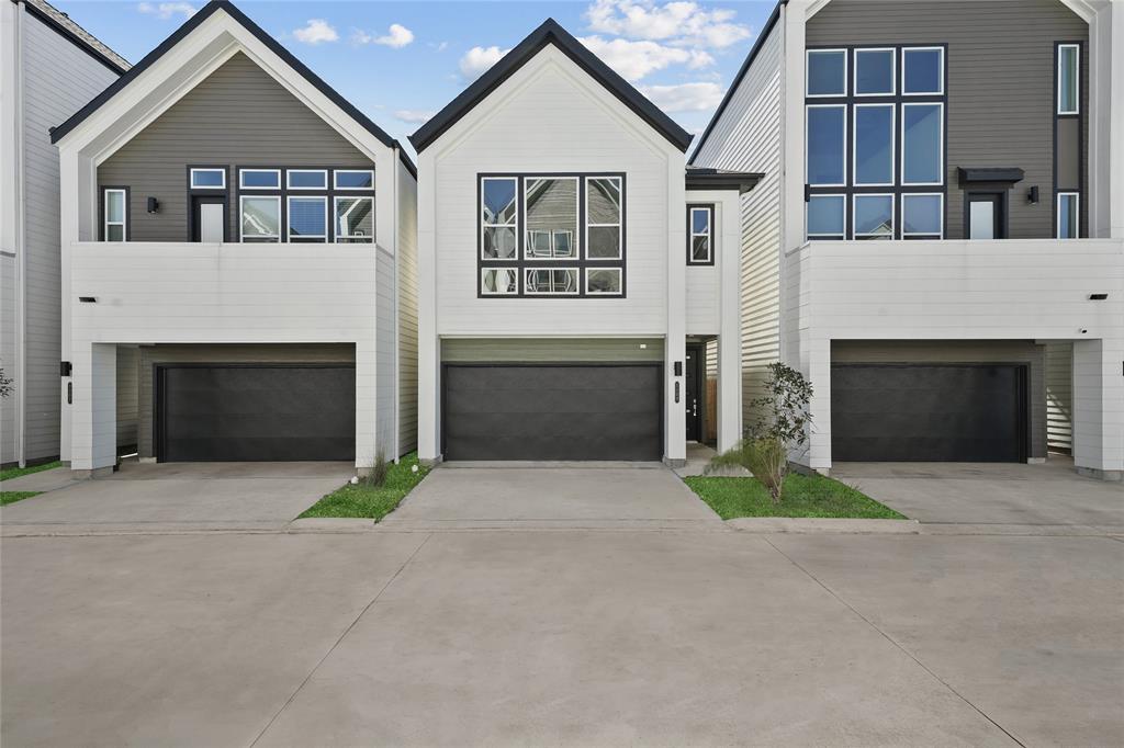 a front view of a house with yard and parking