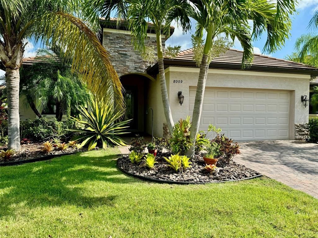 a view of a house with a yard and potted plants