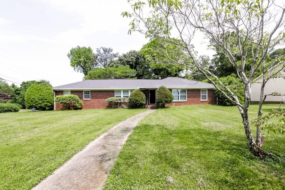 a front view of a house with yard and green space