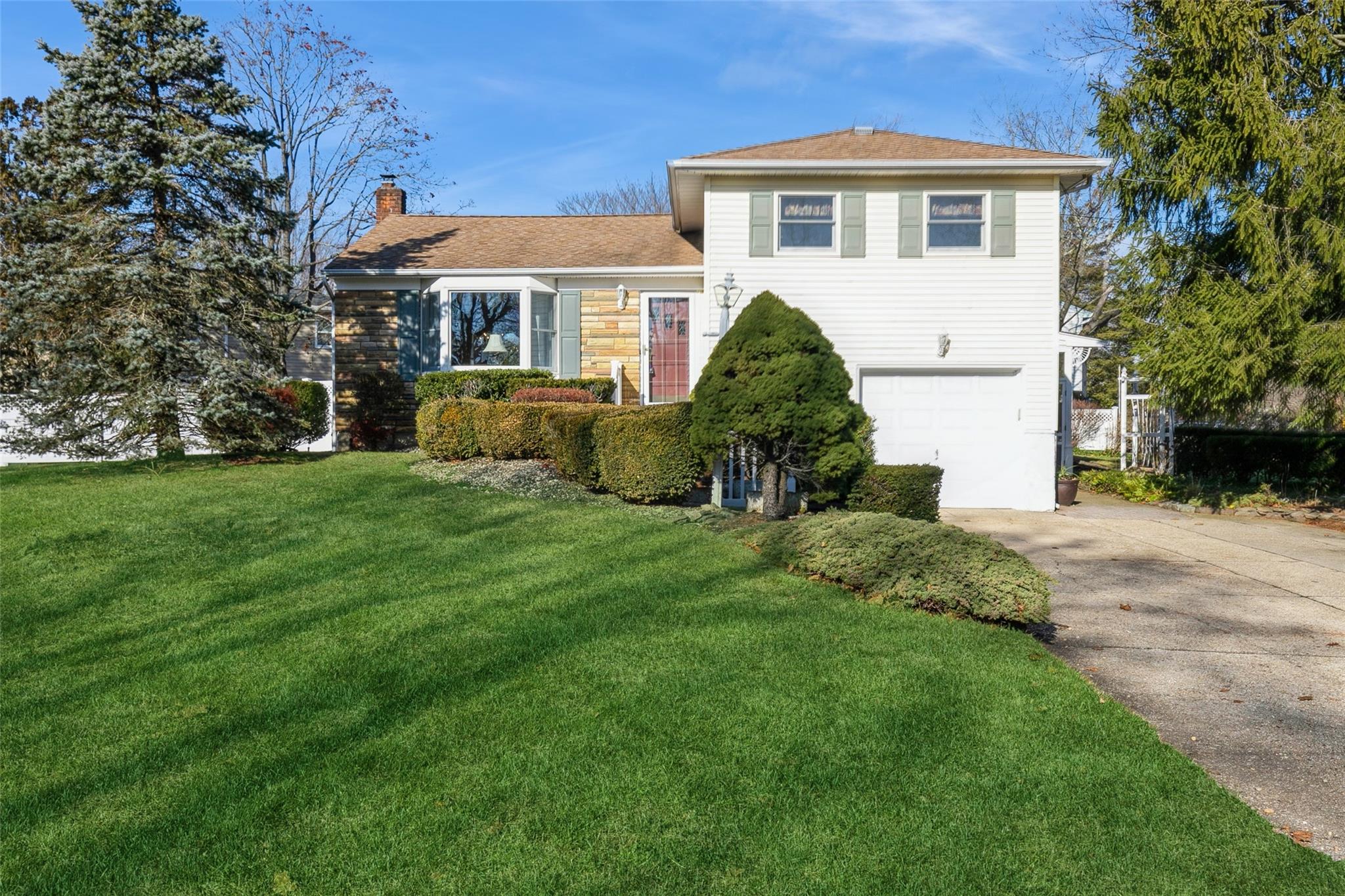 Split level home featuring a front yard and a garage