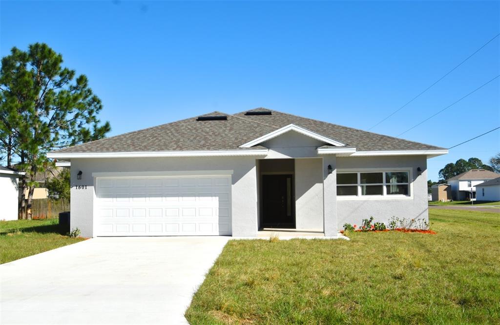 a front view of a house with a garden and yard