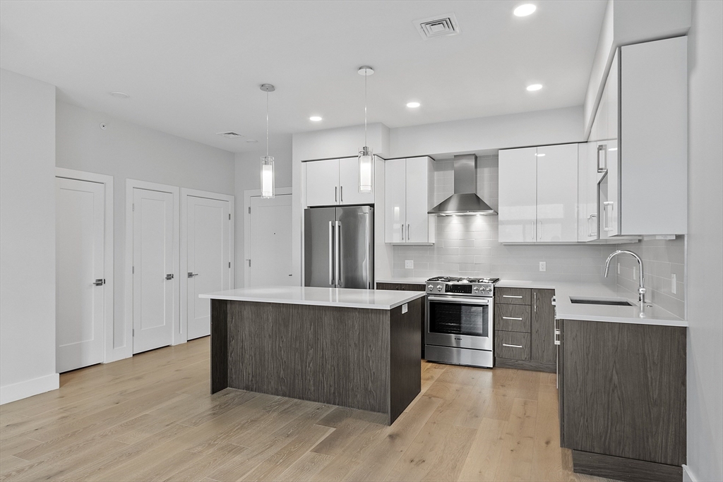 a kitchen with stainless steel appliances granite countertop a sink stove and refrigerator